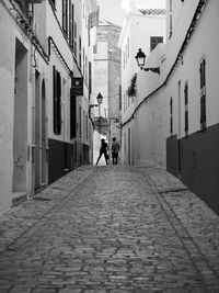 People walking on street amidst buildings in city