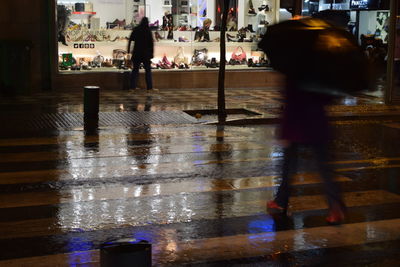 People walking on wet footpath in rainy season