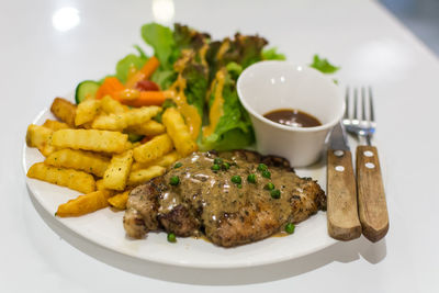 Meat and curry with french fries on plate