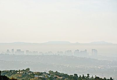 City by mountains against sky