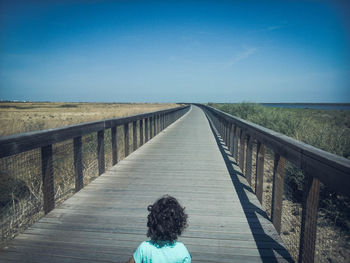 Rear view of woman on footbridge