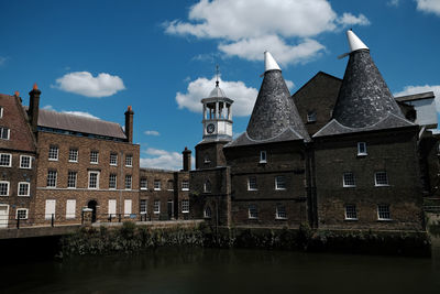 Buildings against cloudy sky