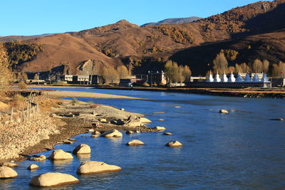 Scenic view of lake and mountains against blue sky