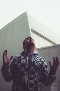 Low angle view of man standing against built structure