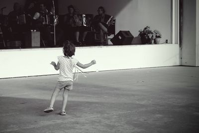 Cute girl dancing on footpath during festival