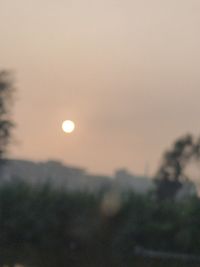 Defocused image of landscape against clear sky during sunset