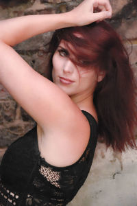 Portrait of young woman with arms raised