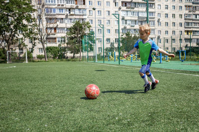 Boy playing with ball in park