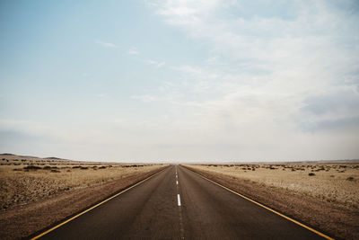 Empty road along countryside landscape