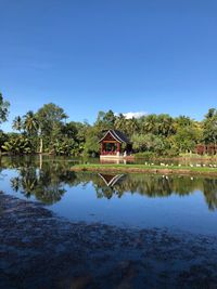 House by lake against building against clear sky