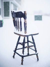 Close-up of empty chair on table in snow