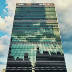 Low angle view of modern building against cloudy sky