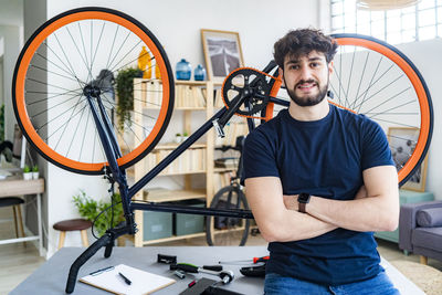 Portrait of young man standing on bicycle