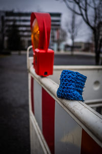 Close-up of blue metallic railing against fence in city