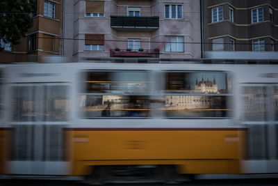 Blurred motion of train against buildings in city