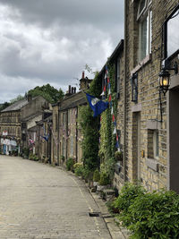 Footpath amidst buildings against sky