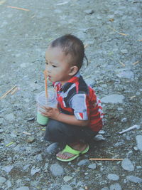 Side view full length of boy with drink glass on field