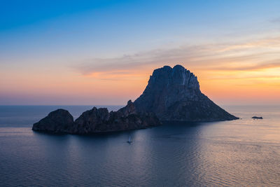 Scenic view of es vedrà island at sunset in mediterranean sea.ibiza
