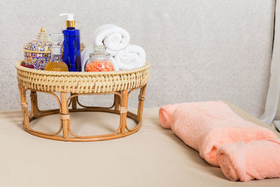 Close-up of beauty products with towels in wicker basket