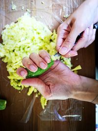 Midsection of woman preparing zuccini on table