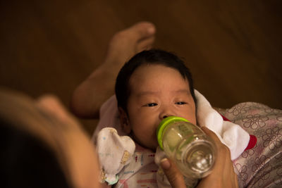 Cropped hand of person feeding baby