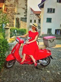 Man riding motorcycle on street amidst buildings in city