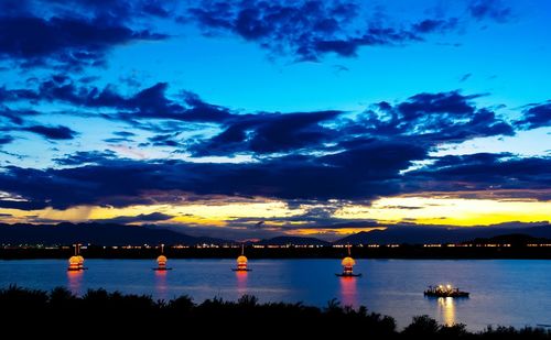 Silhouette bridge over river against sky at sunset
