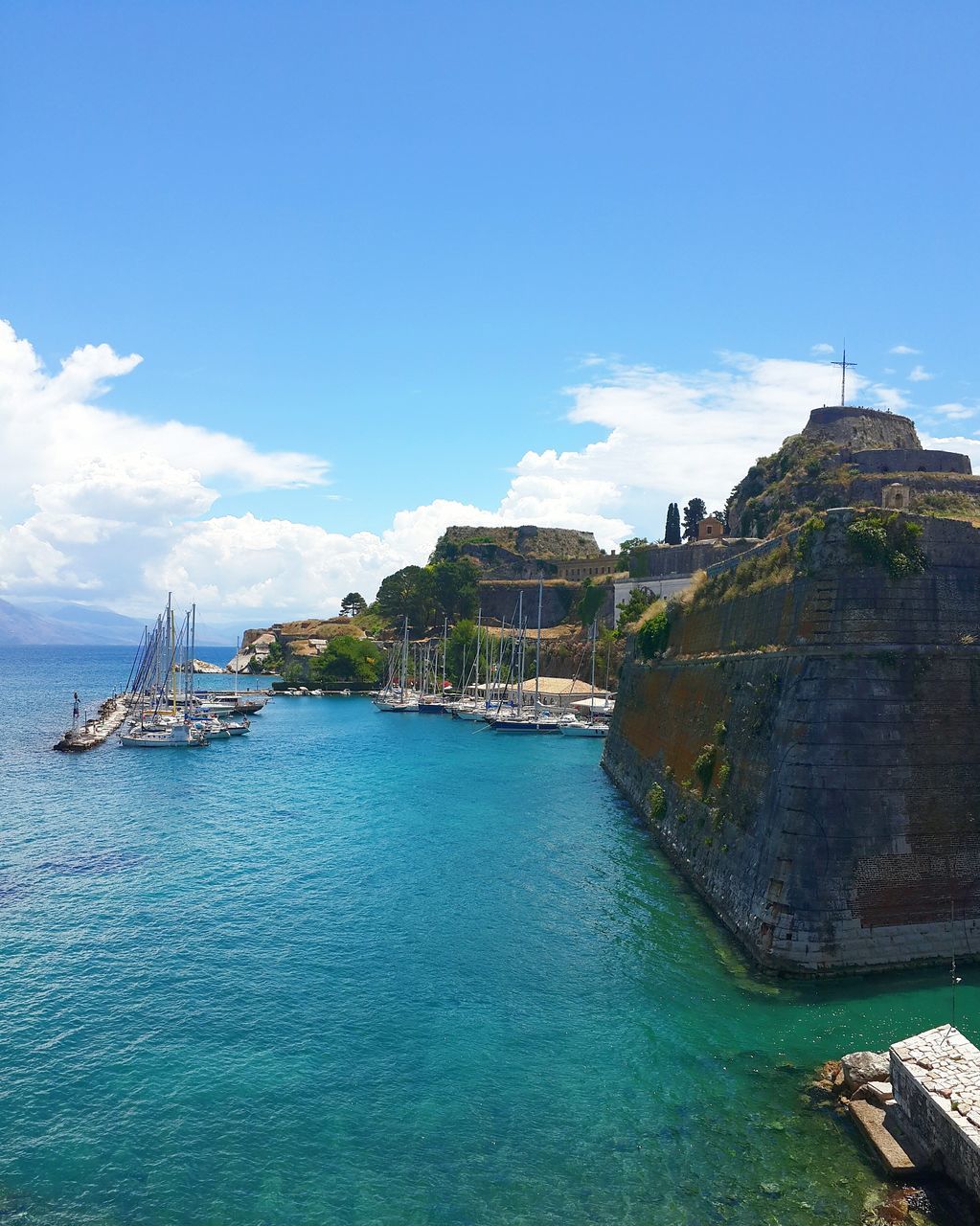 water, sea, architecture, built structure, building exterior, blue, sky, nautical vessel, waterfront, transportation, horizon over water, boat, mode of transport, travel, incidental people, day, travel destinations, tourism, nature, outdoors