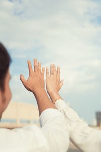 Cropped hand of woman against sky