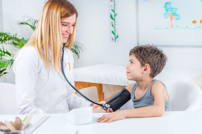 Female doctor examining boy at clinic