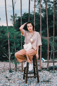 Portrait of young woman sitting on tree