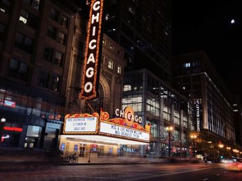 Illuminated sign on street in city at night