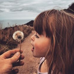 Woman holding dandelion in park