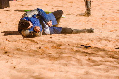 High angle view of man lying on sand