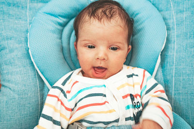 Portrait of cute baby girl on bed at home