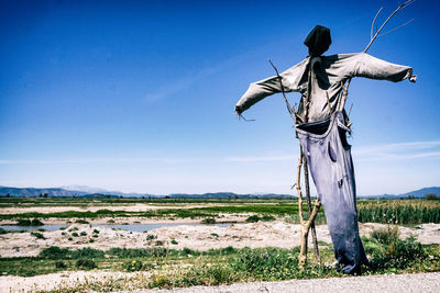 Man standing on field against blue sky