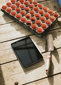 High angle view of digital tablet with soil in container on table