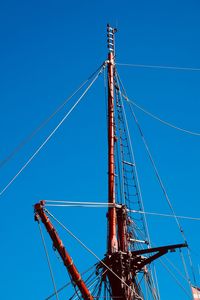 Low angle view of cranes against clear blue sky