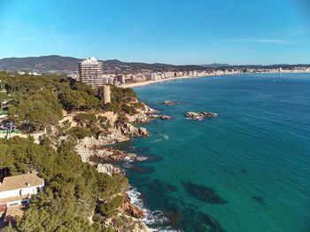 Scenic view of sea and buildings against blue sky