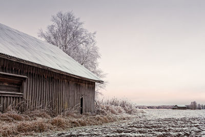 House on field against sky during winter