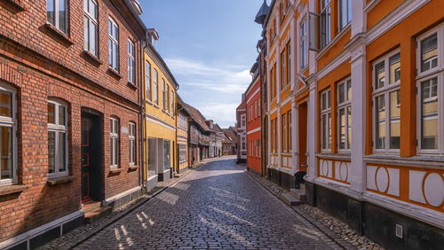 Narrow street amidst buildings against sky