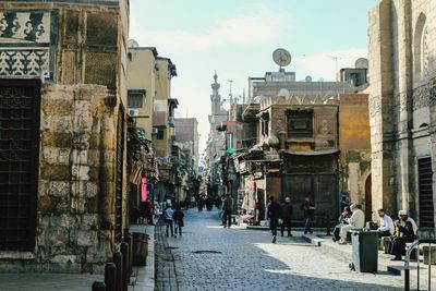 People walking on street against buildings in city