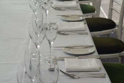 Wineglasses with plates and forks arranged on table