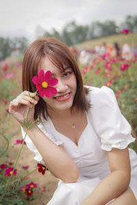 Portrait of young woman holding flower