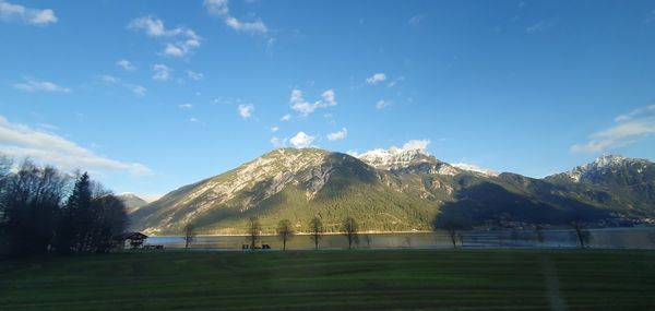 Scenic view of field and mountains against sky