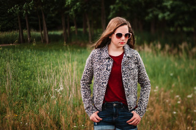 Young woman wearing sunglasses standing in field