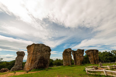 Stone structure on landscape against cloudy sky