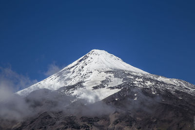 Scenic view of snowcapped mountains against clear blue sky