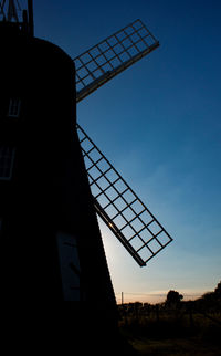 Low angle view of silhouette built structure against clear blue sky