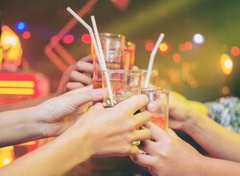 Midsection of woman holding beer glass at night